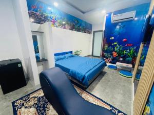 um quarto com uma cama azul e um aquário em NHÀ NGHỈ K house em Ben Tre