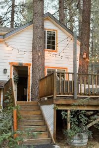 una casa con terraza y un árbol en Aery Pines, en Wrightwood