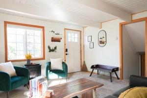 sala de estar con sillas verdes y mesa en Aery Pines en Wrightwood