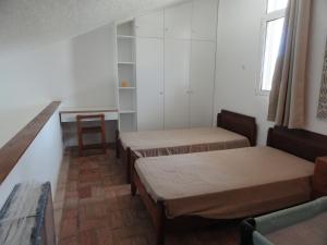 Habitación pequeña con 3 camas y mesa. en Casa de férias in RETUR, praia do Cabeço, Algarve, en Castro Marim
