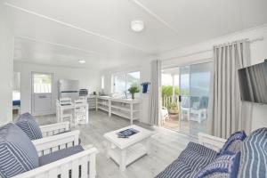 a living room with white furniture and a view of the ocean at Beachcombers in Agulhas