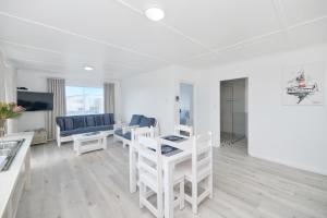 a white living room with a table and chairs at Beachcombers in Agulhas