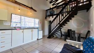 eine Küche mit weißen Schränken und einer Wendeltreppe in der Unterkunft St Mikes Villa in Margate
