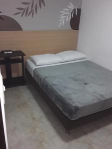 een bed in een kamer met een tafel bij Primavera Hotel in Medellín