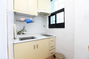 濟州的住宿－Sea View，白色的小厨房,配有水槽和窗户