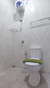 baño con aseo y asiento verde en Shofa boarding house syariah, en Jenggrik