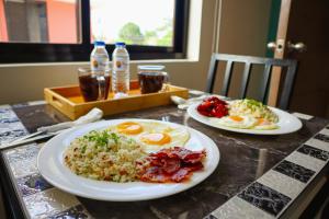 dos platos de comida en una mesa con huevos y arroz en The Oregon Hotel and Drive-inn, en Ángeles