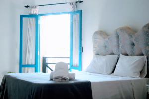 um quarto com uma cama grande e uma janela azul em El Castillo em Las Galeras
