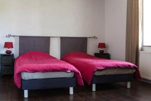 um quarto com 2 camas e cobertores cor-de-rosa em La Grange de Verseilles em Saint-Étienne-de-Vicq
