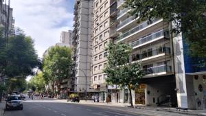 una calle de la ciudad con un edificio blanco alto en Buenos Aires PALERMO - RECOLETA en Buenos Aires