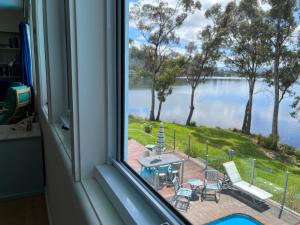 a window looking out at a view of a lake at Anchorage Waterfront Retreat in Castle Forbes Bay