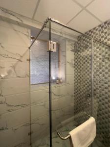 baño con ducha y puerta de cristal en Nadis - A handcrafted boutique hotel en Srinagar