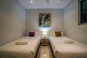 达尔文ZEN CENTRAL Ambient 3BR Apt in the Heart of Darwin的带灯的客房内的两张单人床