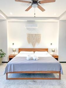 1 dormitorio con 1 cama grande y ventilador de techo en Balam Suites, en Playa del Carmen