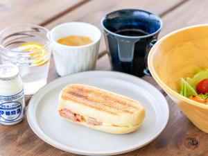 uma sanduíche num prato ao lado de uma tigela de comida em ITOSHIMA SDGs Village Chikyu MIRAI -Floating Art room or Bali Forest room- em Itoshima