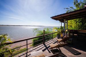 um deque com bancos e vista para a água em Nakorn River View em Champassak