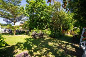 a yard with a table and chairs and trees at Nakorn River View in Champasak