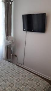 TV de pantalla plana en la pared de un dormitorio en DEPARTAMENTOS SANTIAGO CENTRO # 5, en Santiago