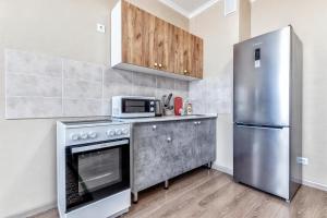 a kitchen with a stove and a refrigerator at Квартира в центре города 15-этаж in Astana +4 photos