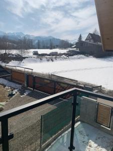widok na pokryty śniegiem dziedziniec z basenem w obiekcie Czarny Baran w Zakopanem