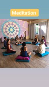 a group of people sitting in a yoga class at Alma Double Room Garden View in Rivas