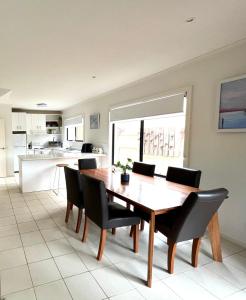 a kitchen and dining room with a wooden table and chairs at Captains Nook Cowes in Cowes
