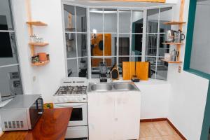 uma pequena cozinha com um lavatório e um fogão em Samay Hostel em Juayúa