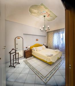 a bedroom with a bed and a chandelier at La Finestra sul Mare in Ischia