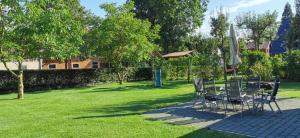 a group of chairs and umbrellas on a lawn at Ferienhaus Hünzingen in Walsrode