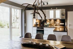 eine Küche mit einem Holztisch und Stühlen in der Unterkunft Ferienhaus Hünzingen in Walsrode