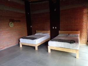 two beds sitting next to a brick wall at Casa Ejutla de Crespo, Oaxaca 