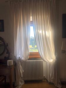 ein Fenster mit weißen Vorhängen und einem Heizkörper in einem Zimmer in der Unterkunft Luxury apartment Sutri center in Sutri