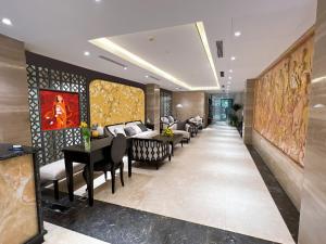 un couloir avec des chaises et des tables dans le hall de l'hôtel dans l'établissement Skylark Hotel, à Hanoï
