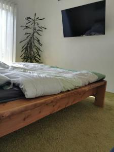 a bed sitting on a wooden frame in a room at Bungalow mit 200 qm Wohnfläche :) in Birgland