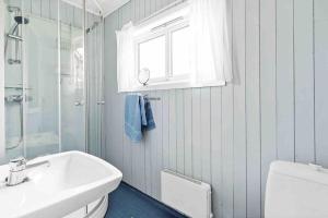 a bathroom with a sink and a toilet and a window at House by the ocean with midnight sun view in Eggum