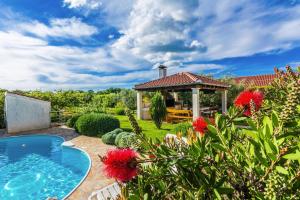 um jardim com uma piscina e um gazebo em Apartments Rosmary, Zaton, with pool em Zaton