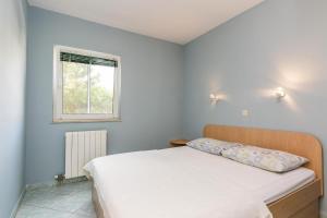 um quarto com uma cama branca e uma janela em Apartments Rosmary, Zaton, with pool em Zaton