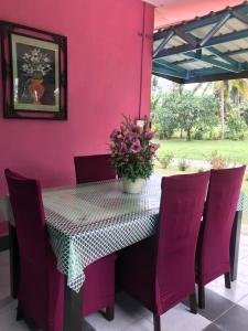 een tafel met stoelen en een vaas met bloemen erop bij Seri Pengkalan Homestay in Bachok