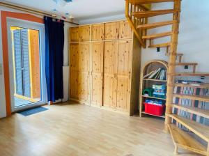 Habitación con armarios de madera y escalera de caracol. en Hundeparadies Waldblick Lauenstein, en Ludwigsstadt