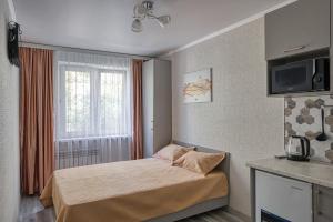 a small bedroom with a bed and a window at Апарт 33 in Almaty +28 photos