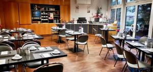 um restaurante com mesas e cadeiras e uma cozinha em ALFA Hotel em Berlim