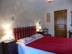 ein Schlafzimmer mit einem roten Bett mit zwei Kissen in der Unterkunft Gîte Deneuille-les-Mines, 4 pièces, 6 personnes - FR-1-489-408 in Deneuille-les-Mines