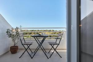 a table and two chairs on a balcony with a view at Charm Hotel, Hersonissos in Hersonissos