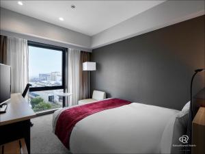 a hotel room with a bed and a large window at Daiwa Roynet Hotel Kanazawa Eki Nishiguchi in Kanazawa