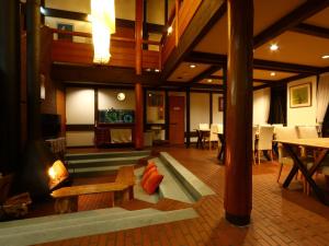 a living room with a fireplace and tables and chairs at Villa Monrepos in Myoko