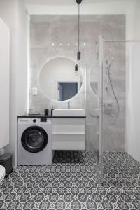 y baño con lavadora y espejo. en Apartament Harmonia Gdańsk, blisko morza. en Gdansk