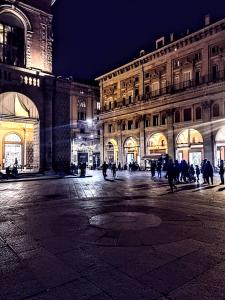 un gruppo di persone che camminano intorno a un edificio di notte di Affittacamere di Andrea Bertolino Bologna a Bologna