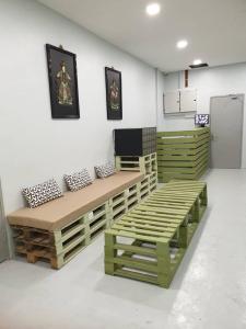 a room with wooden benches and a refrigerator at MyPods @ Bukit Bintang in Kuala Lumpur
