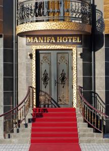 a red carpeted staircase leading to a hotel with a door at Manifa Hotel in Tashkent