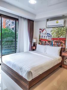 een slaapkamer met een groot bed en een groot raam bij MBC Mai Khao Beach Condotel LUXURY APARTMENTs in Phuket